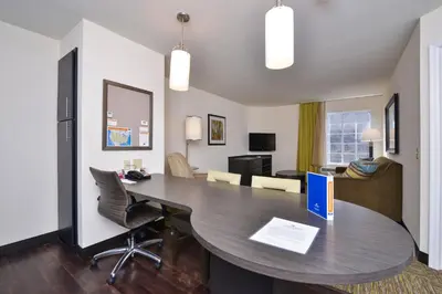 a room with a table and chairs and a living room at Candlewood Suites Harrisburg-Hershey by IHG in Harrisburg