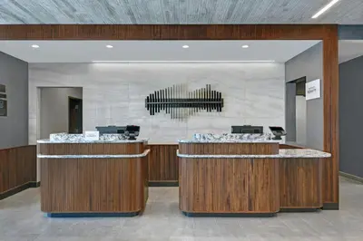 a lobby with a reception desk and a chandelier at Courtyard by Marriott Hamilton in Hamilton