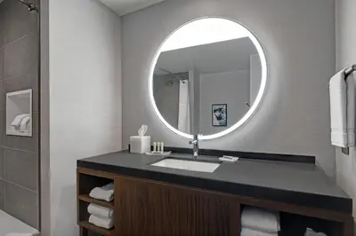 a bathroom with a sink and a mirror at Courtyard by Marriott Hamilton in Hamilton
