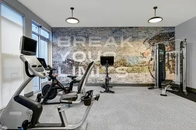 a gym with cardio equipment and a brick wall at Courtyard by Marriott Hamilton in Hamilton