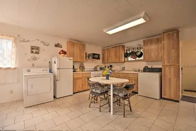 a kitchen with white appliances and a table with chairs at Private Hot Tub and Fireplace Poconos Home! in Pleasant Mount
