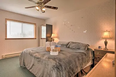a bedroom with a bed with two chairs on it at Private Hot Tub and Fireplace Poconos Home! in Pleasant Mount