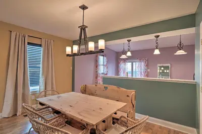 a dining room with a wooden table and chairs at Colorful Abode with Yard, 9 Mi to Sesame Place! in Bristol