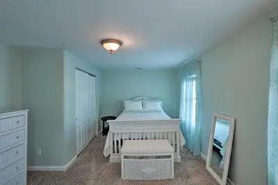 a bedroom with a white bed and a mirror at Colorful Abode with Yard, 9 Mi to Sesame Place! in Bristol
