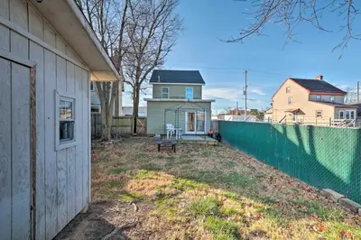 a yard next to a house with a fence at Colorful Abode with Yard, 9 Mi to Sesame Place! in Bristol