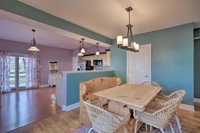 a kitchen and dining room with a wooden table and chairs at Colorful Abode with Yard, 9 Mi to Sesame Place! in Bristol