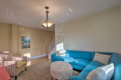 a living room with a blue couch and chairs at Colorful Abode with Yard, 9 Mi to Sesame Place! in Bristol