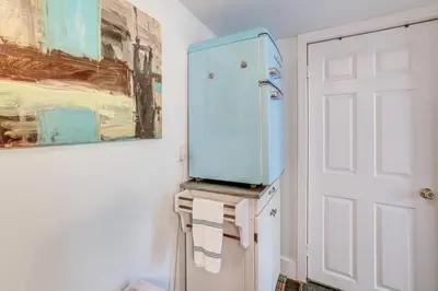 a refrigerator in a kitchen with a painting on the wall at Charming Getaway Less Than 1 Mi to Downtown Lambertville! in Lambertville
