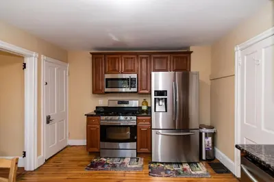 a kitchen with wooden cabinets and a stainless steel refrigerator at 915CountyLineRoad Luxury Mainline Train Colleges in Bryn Mawr