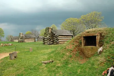 a group of log buildings on a grassy hill at 915CountyLineRoad Luxury Mainline Train Colleges in Bryn Mawr