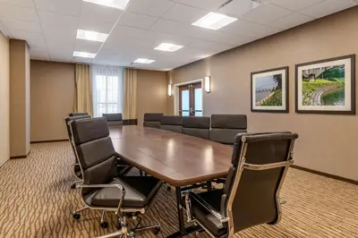 a conference room with a wooden table and chairs at Comfort Suites Camp Hill-Harrisburg West in Harrisburg