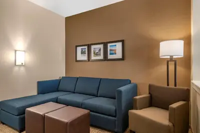 a living room with a blue couch and a chair at Comfort Suites Camp Hill-Harrisburg West in Harrisburg