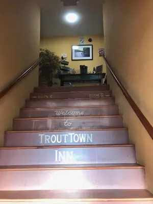 a stairway with a sign that says welcome to front townin at Trout Town Inn in Roscoe