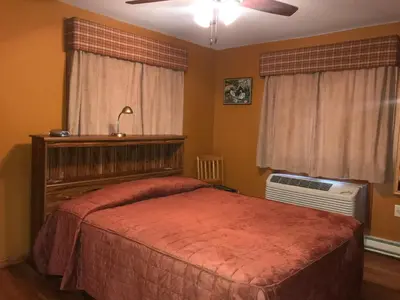 a bedroom with a large bed and a fan at Trout Town Inn in Roscoe