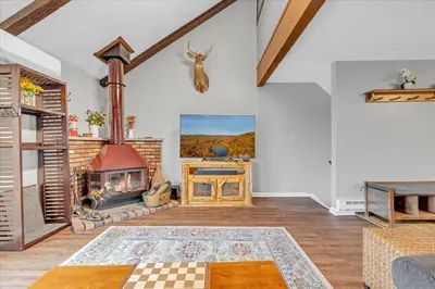 a living room with a fireplace and a table at 180 SKI CAMELBACK-SKI-ON -SKI OFF,SNOW TUBING,Paintball in Tannersville