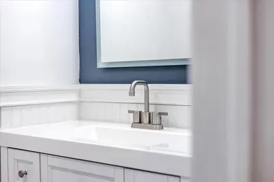 a white kitchen with a sink and a mirror at 180 SKI CAMELBACK-SKI-ON -SKI OFF,SNOW TUBING,Paintball in Tannersville