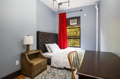 a bedroom with a bed and a table and a window at Lamartine Chelsea in New York