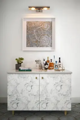 a kitchen with a white counter with a painting on the wall at The Wall Street Hotel New York City in New York