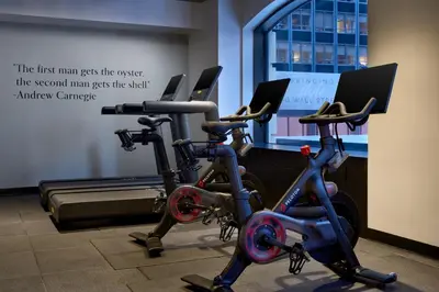 a gym with three exercise bikes in a room at The Wall Street Hotel New York City in New York
