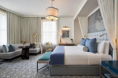 a bedroom with a large bed and a living room at The Wall Street Hotel New York City in New York