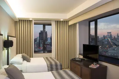 a hotel room with a bed and a large window at Leon Hotel LES in New York