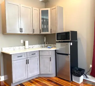 a kitchen with white cabinets and a microwave and a refrigerator at AF Stays - Philadelphia 1224 Mt Vernon St in Philadelphia