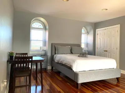 a bedroom with a bed and a table and two windows at AF Stays - Philadelphia 1224 Mt Vernon St in Philadelphia