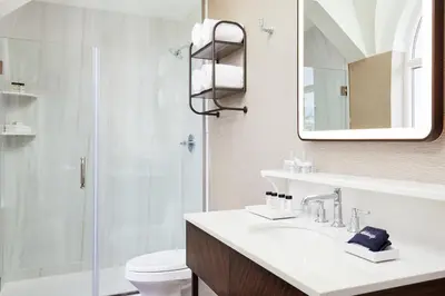 a bathroom with a toilet and a sink and a shower at The Chateau Grande Hotel in East Brunswick