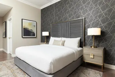 a bedroom with a large bed and two lamps at The Chateau Grande Hotel in East Brunswick