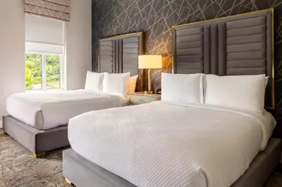 a bedroom with two beds and a window at The Chateau Grande Hotel in East Brunswick