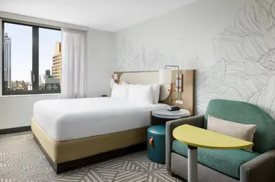 a hotel room with a bed and a chair at SpringHill Suites by Marriott New York Manhattan Chelsea in New York