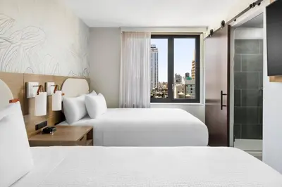 a hotel room with two beds and a window at SpringHill Suites by Marriott New York Manhattan Chelsea in New York