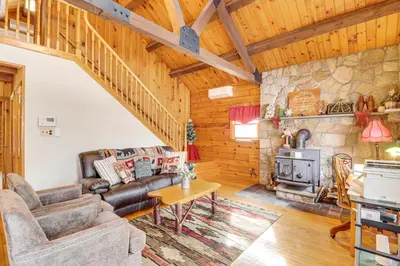 a living room with a couch and a stove at Hike and Ski Log Cabin in East Stroudsburg! in East Stroudsburg