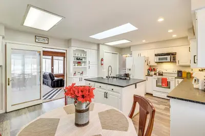 a kitchen with a table with a vase of flowers on it at Hike and Ski Log Cabin in East Stroudsburg! in East Stroudsburg