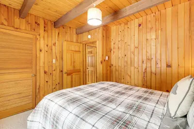 a bedroom with a bed in a wooden room at Hike and Ski Log Cabin in East Stroudsburg! in East Stroudsburg