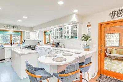 a kitchen with white cabinets and a table and chairs at 4 Mi to Slopes! Split Rock Resort Home with Fire Pit in Lake Harmony