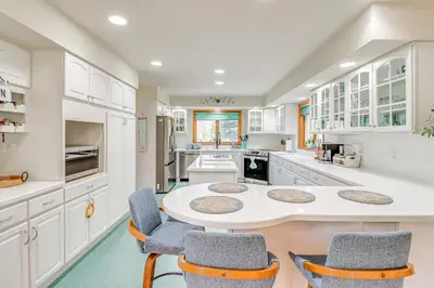 a white kitchen with a table and chairs at 4 Mi to Slopes! Split Rock Resort Home with Fire Pit in Lake Harmony