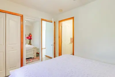 a bedroom with a white bed and a mirror at 4 Mi to Slopes! Split Rock Resort Home with Fire Pit in Lake Harmony