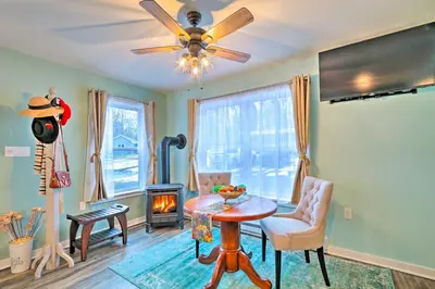 a living room with a table and a ceiling fan at Unwind Fireside! Poconos Cottage 12 Mi to Slopes in Brodheadsville