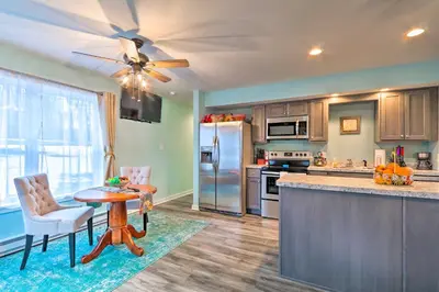 a kitchen with a refrigerator and a table and chairs at Unwind Fireside! Poconos Cottage 12 Mi to Slopes in Brodheadsville