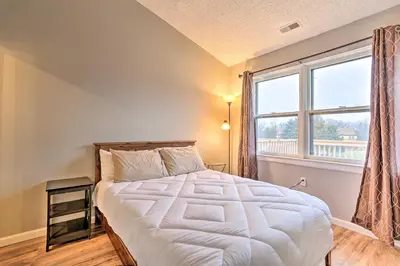 a bedroom with a bed and a large window at Inviting Poconos Getaway with Deck Ski and Hike! in Mount Pocono