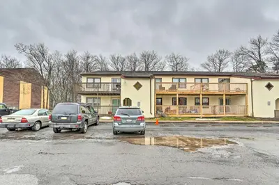 two cars parked in a parking lot in front of a building at Inviting Poconos Getaway with Deck Ski and Hike! in Mount Pocono