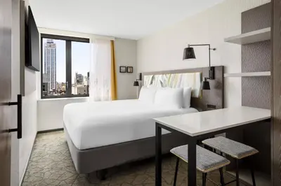 a hotel room with a bed and a desk and a window at TownePlace Suites by Marriott New York Manhattan/Chelsea in New York