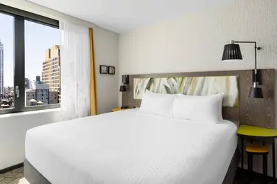 a bedroom with a large white bed and a window at TownePlace Suites by Marriott New York Manhattan/Chelsea in New York