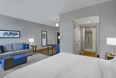 a bedroom with a bed and a living room at Homewood Suites By Hilton Edison Woodbridge, NJ in Edison