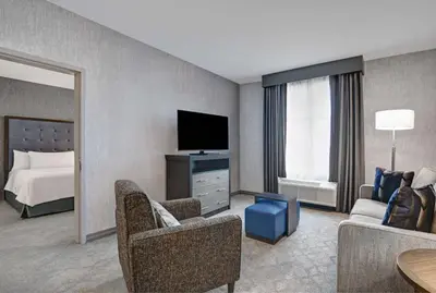a hotel room with a bed and a living room at Homewood Suites By Hilton Edison Woodbridge, NJ in Edison