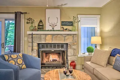 a living room with a fireplace with a couch and a table at Cozy Poconos Townhome with Fireplace Near Jack Frost in Lake Harmony