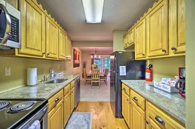 a kitchen with wooden cabinets and a counter top at Cozy Poconos Townhome with Fireplace Near Jack Frost in Lake Harmony