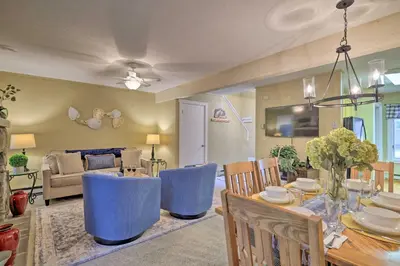 a dining room and living room with a table and chairs at Cozy Poconos Townhome with Fireplace Near Jack Frost in Lake Harmony