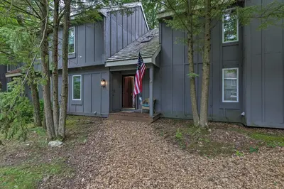 a house with a flag in front of it at Cozy Poconos Townhome with Fireplace Near Jack Frost in Lake Harmony
